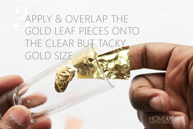 Finger laying gold leaf inside a shot glass