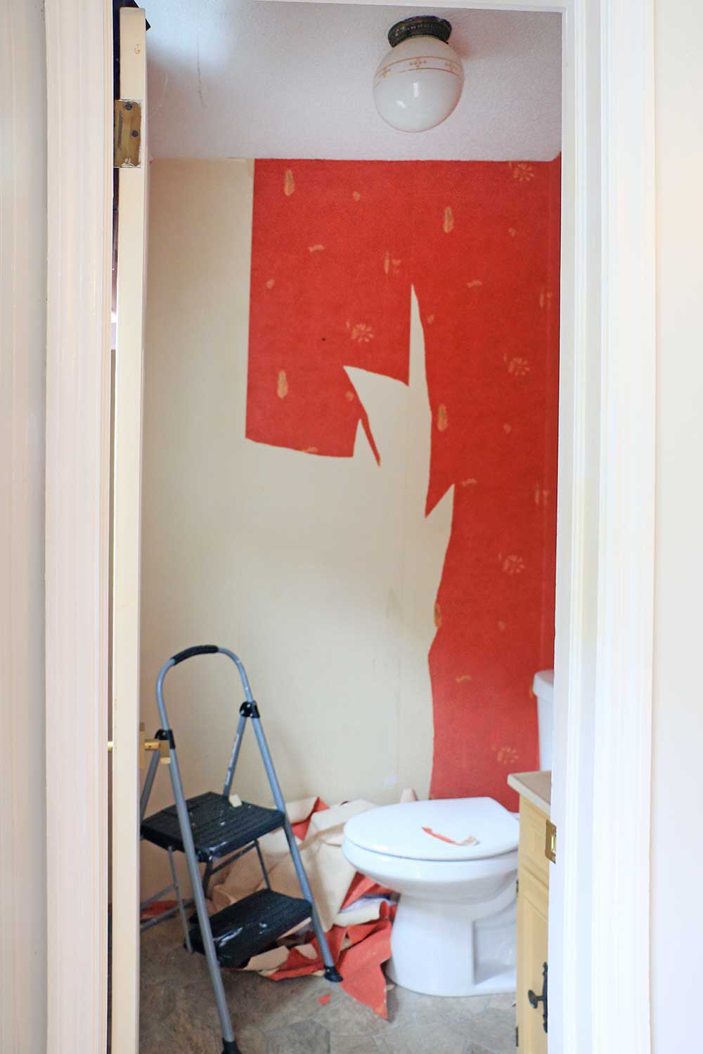 Powder-room-with-red-peeling-wallpaper