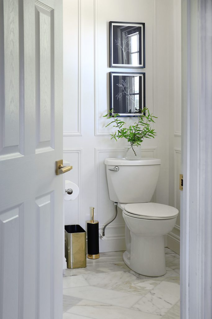 Bathroom with framed art over the toilet